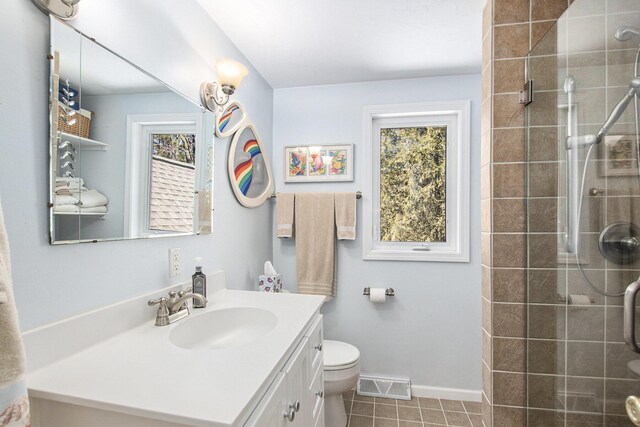 full bathroom featuring vanity, toilet, baseboards, a stall shower, and visible vents