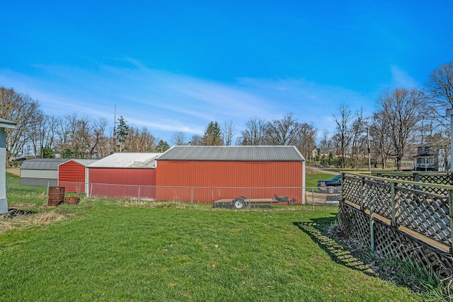 view of yard with an outdoor structure, a pole building, and fence