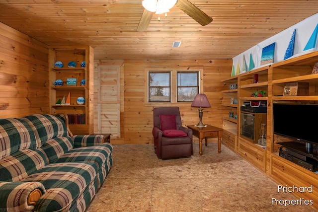 living area featuring carpet flooring, ceiling fan, wood walls, and wooden ceiling