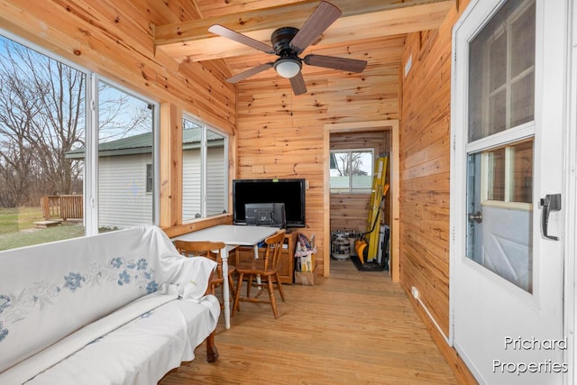 sunroom featuring a ceiling fan and beamed ceiling