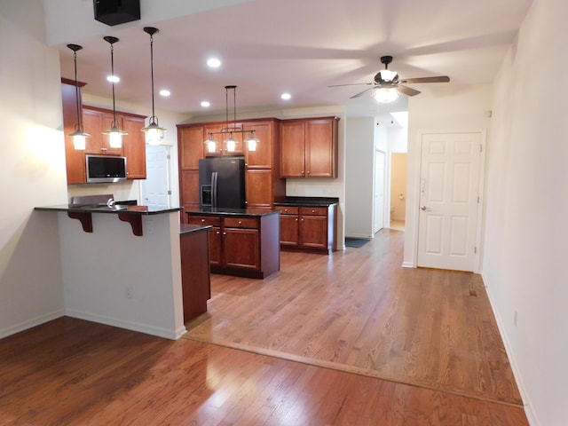 2535 Holiday House Rd Unit 24, Saint Joseph, MI 49085 - kitchen with black refrigerator with ice dispenser, dark countertops, a peninsula, a ceiling fan, and wood finished floors