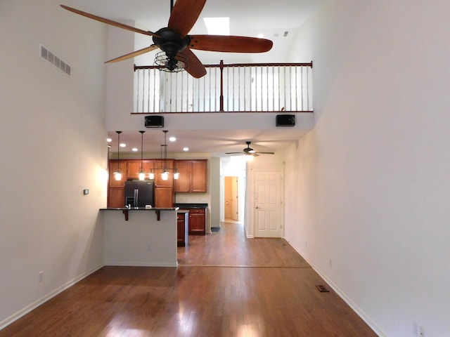 2535 Holiday House Rd Unit 24, Saint Joseph, MI 49085 - unfurnished living room featuring ceiling fan, dark wood-style flooring, baseboards, and a towering ceiling
