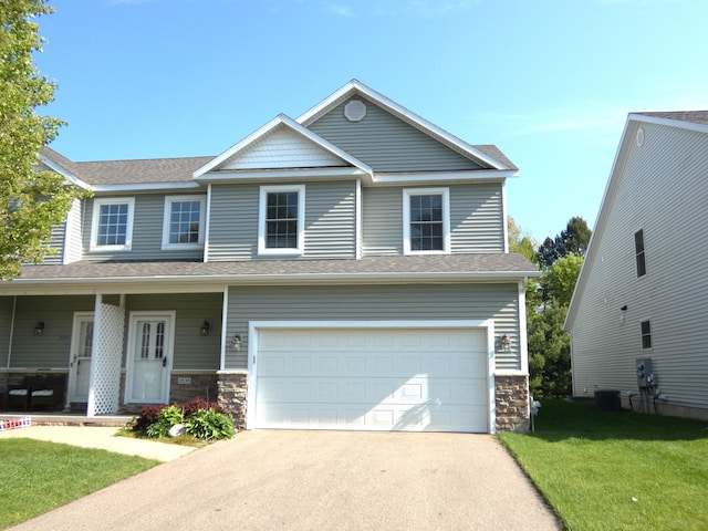 2535 Holiday House Rd Unit 24, Saint Joseph, MI 49085 - view of front of house with stone siding, a front yard, driveway, an attached garage, and central AC unit