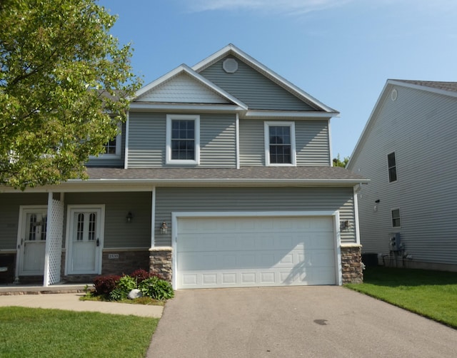 2535 Holiday House Rd Unit 24, Saint Joseph, MI 49085 - view of front of home with an attached garage, stone siding, driveway, and a front yard