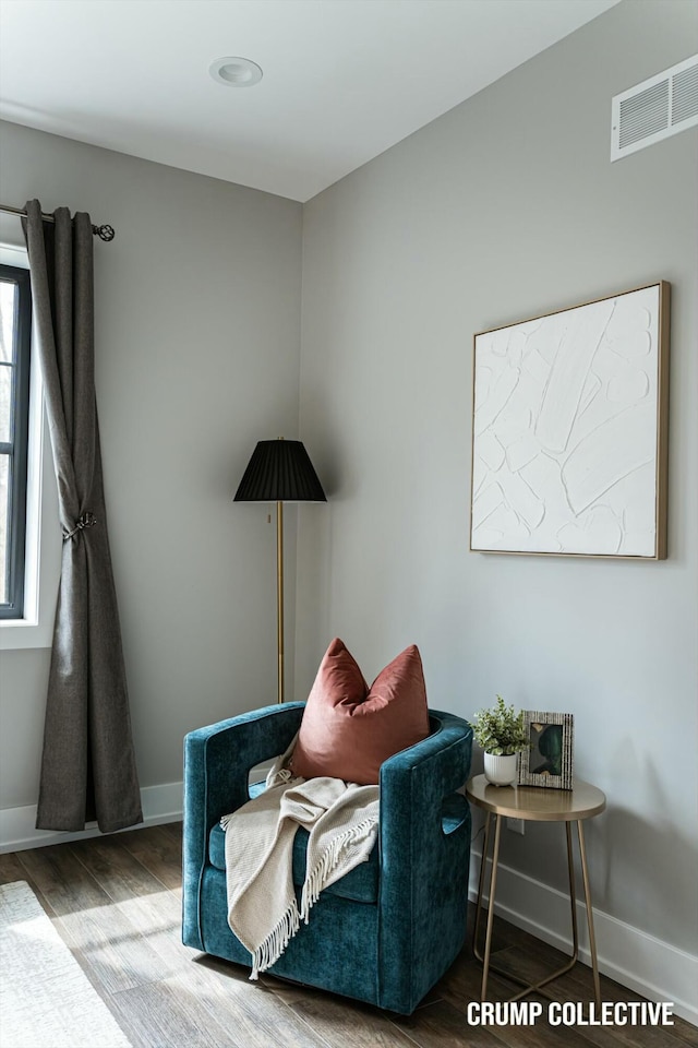 sitting room with baseboards, visible vents, and wood finished floors