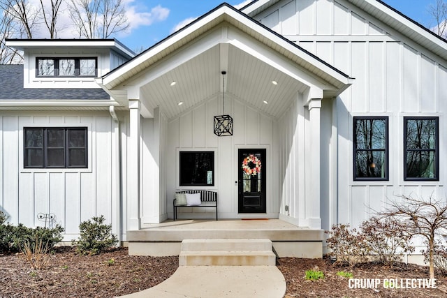 entrance to property with board and batten siding, a porch, and a shingled roof