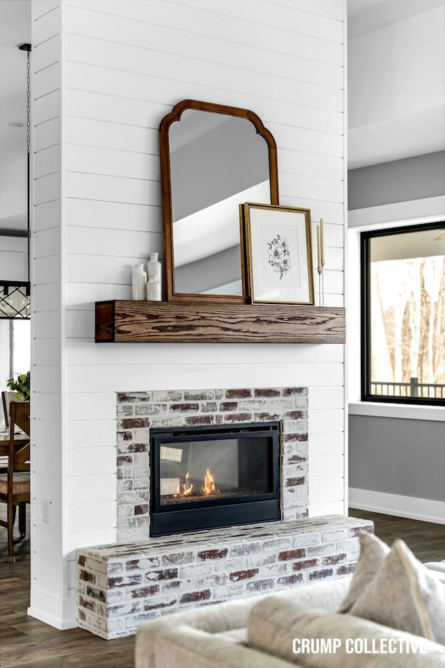 room details featuring baseboards, a fireplace, and wood finished floors