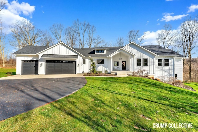 modern inspired farmhouse featuring driveway, a front yard, an attached garage, and board and batten siding