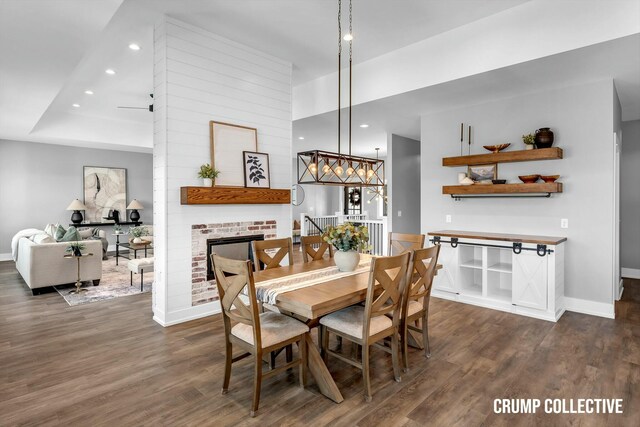 dining area with baseboards, dark wood-type flooring, and a brick fireplace
