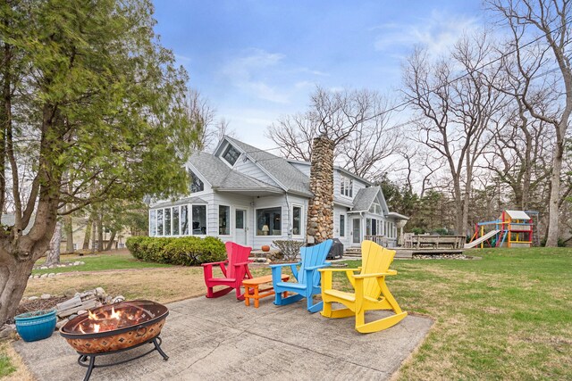 4117 Lake Shore Dr, New Buffalo, MI 49117 - view of playground with a deck, a fire pit, a yard, a patio, and a sunroom