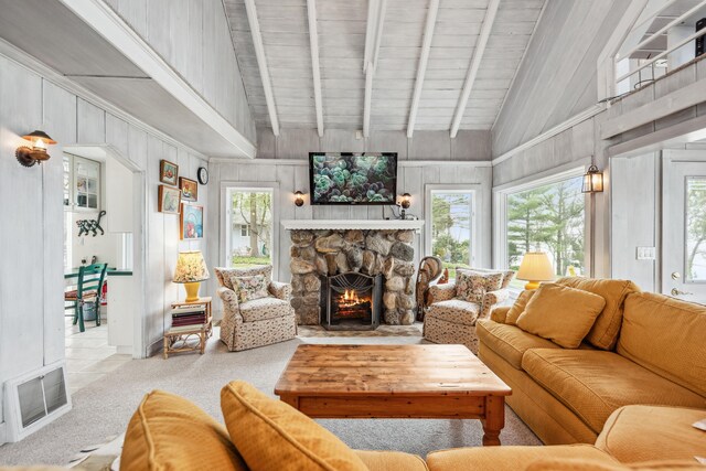 4117 Lake Shore Dr, New Buffalo, MI 49117 - carpeted living room featuring a healthy amount of sunlight, a stone fireplace, visible vents, and vaulted ceiling with beams