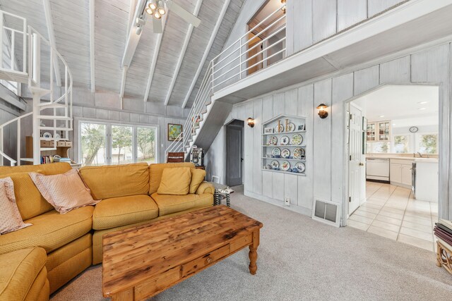 4117 Lake Shore Dr, New Buffalo, MI 49117 - carpeted living area with stairway, wood walls, visible vents, beamed ceiling, and high vaulted ceiling
