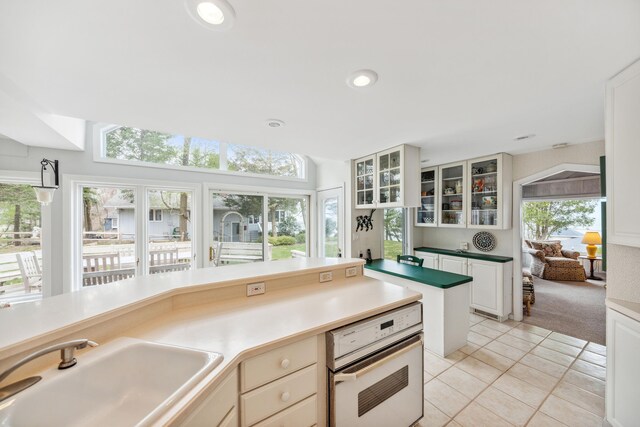 4117 Lake Shore Dr, New Buffalo, MI 49117 - kitchen featuring oven, a sink, light tile patterned flooring, recessed lighting, and glass insert cabinets