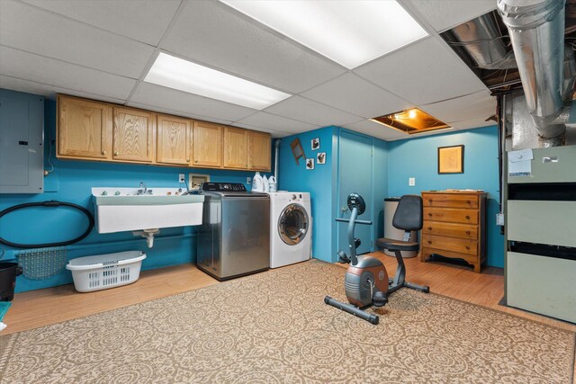 33028 Pokagon Hwy, Niles, MI 49120 - clothes washing area with electric panel, a sink, light wood-style floors, cabinet space, and washer and clothes dryer