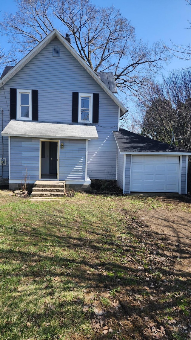 rear view of house featuring a detached garage, dirt driveway, and a lawn