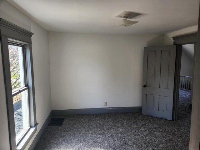 empty room with visible vents, carpet flooring, and baseboards