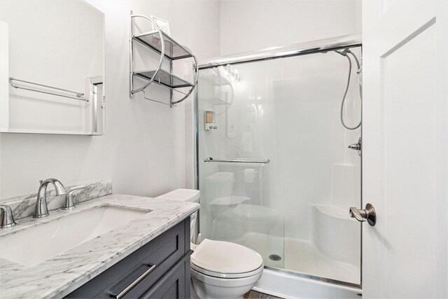 1641 N Arrowhead Rd, Mears, MI 49436 - bathroom featuring toilet, a stall shower, and vanity