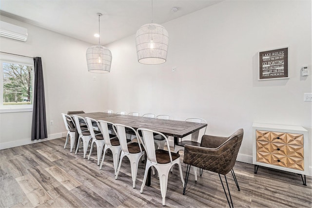 1641 N Arrowhead Rd, Mears, MI 49436 - dining room with baseboards, a wall unit AC, and wood finished floors