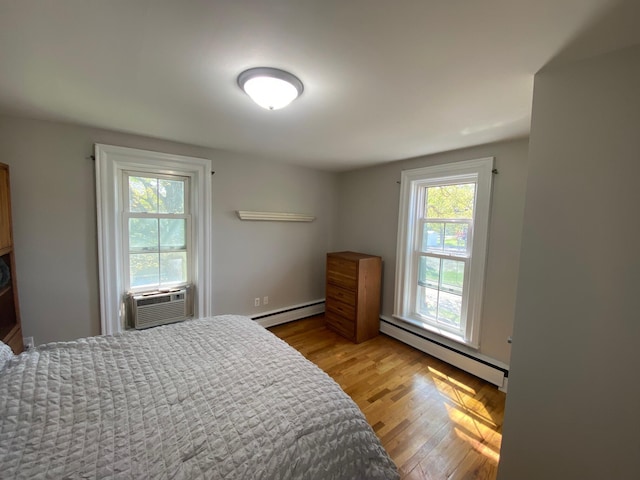 227 Railroad St, Chelsea, MI 48118 - bedroom featuring baseboard heating, light wood-type flooring, and cooling unit