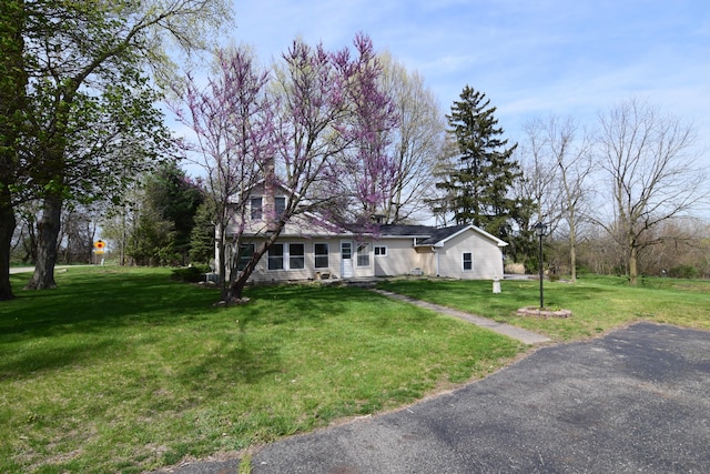 view of front of house with a chimney and a front lawn