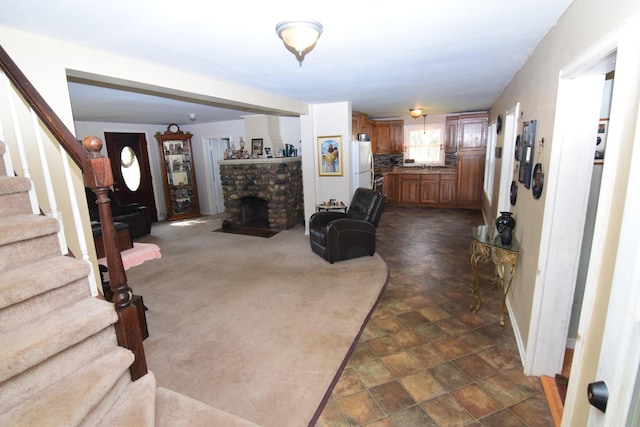 living room with stairs, stone finish flooring, baseboards, and a fireplace with flush hearth