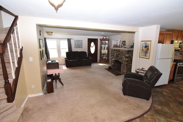 living area featuring a stone fireplace and stairs