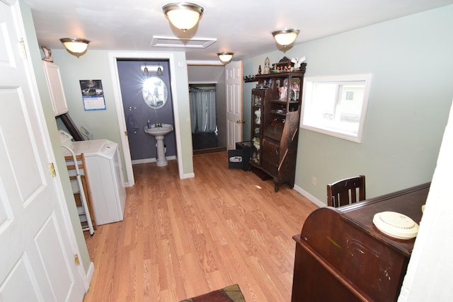 interior space with washer and dryer, baseboards, and light wood-style flooring