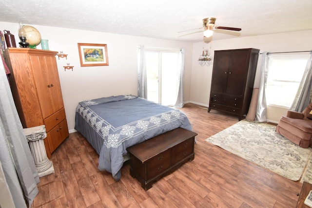 bedroom with baseboards, ceiling fan, and wood finished floors