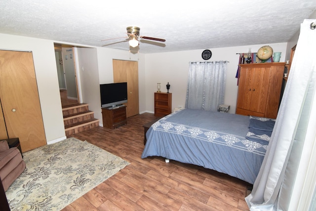 bedroom with a ceiling fan, a textured ceiling, and wood finished floors