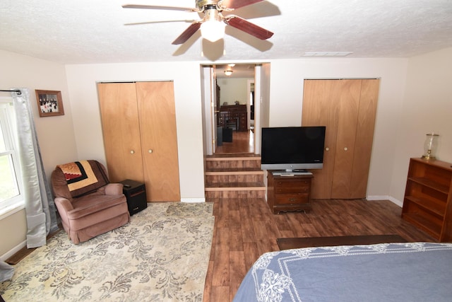 bedroom featuring visible vents, wood finished floors, baseboards, ceiling fan, and a textured ceiling
