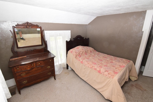 bedroom featuring vaulted ceiling and light carpet