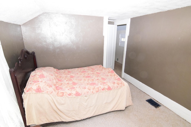 carpeted bedroom featuring baseboards, lofted ceiling, and visible vents