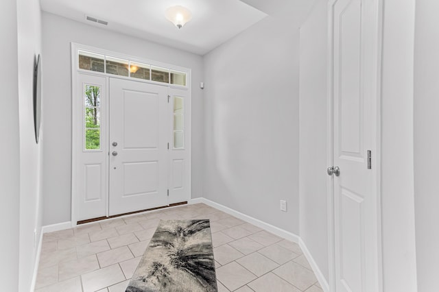 entryway featuring baseboards, visible vents, and light tile patterned floors