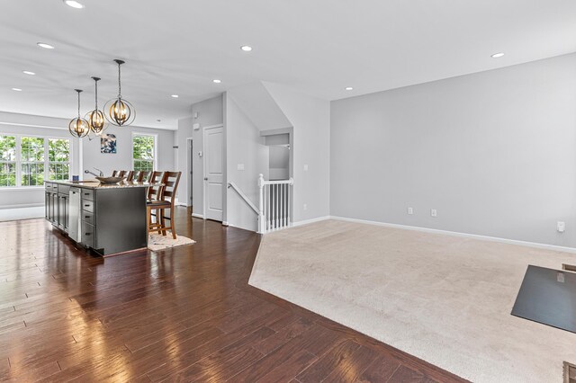 living area featuring dark wood-style flooring, a notable chandelier, baseboards, and recessed lighting