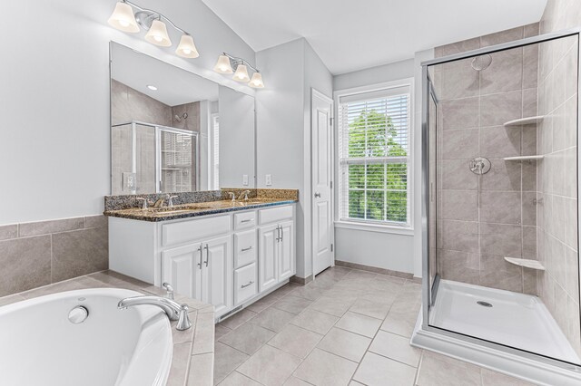 full bathroom with tile patterned flooring, a sink, a stall shower, double vanity, and a bath