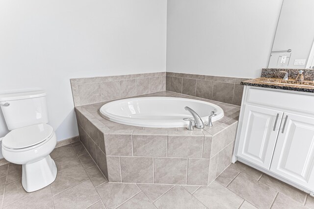 bathroom featuring toilet, vanity, tile patterned floors, and a garden tub