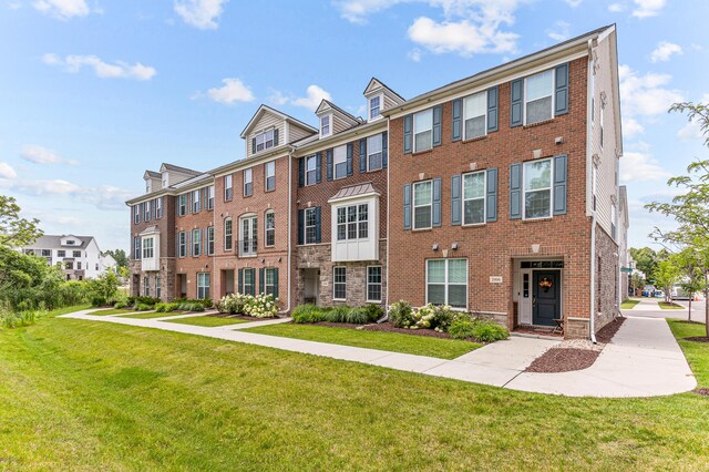 view of front of property with brick siding and a front lawn