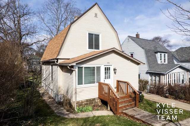 135 Houseman Ave NE, Grand Rapids, MI 49503 - rear view of property featuring a gambrel roof, a shingled roof, and a chimney