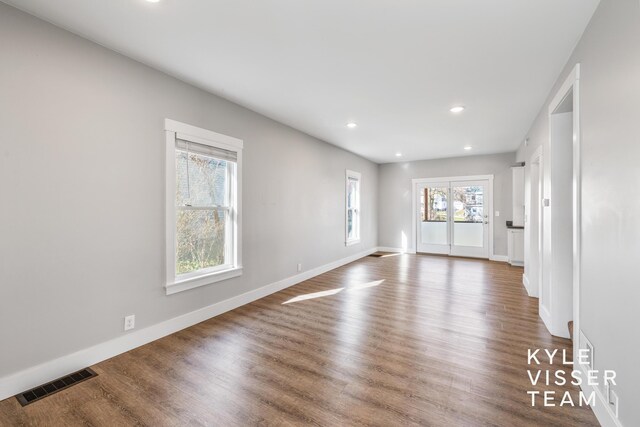 135 Houseman Ave NE, Grand Rapids, MI 49503 - unfurnished living room with wood finished floors, recessed lighting, baseboards, and visible vents