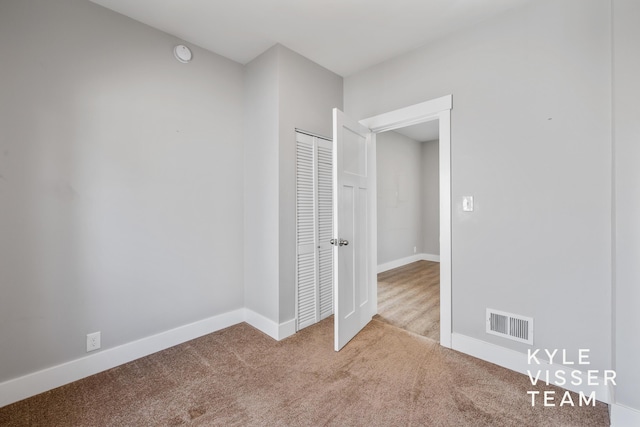 135 Houseman Ave NE, Grand Rapids, MI 49503 - unfurnished bedroom featuring carpet floors, a closet, baseboards, and visible vents