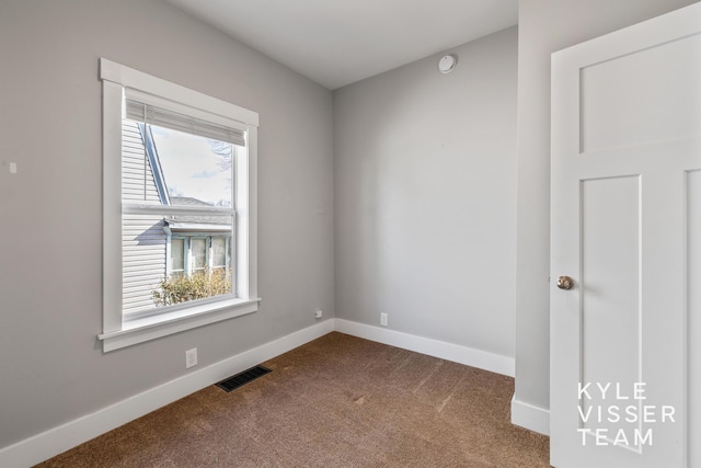 135 Houseman Ave NE, Grand Rapids, MI 49503 - empty room with baseboards, visible vents, and dark colored carpet