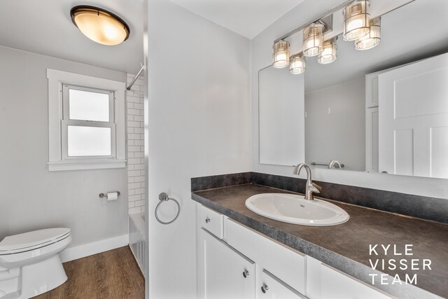 135 Houseman Ave NE, Grand Rapids, MI 49503 - bathroom featuring toilet, vanity, shower / tub combination, wood finished floors, and baseboards