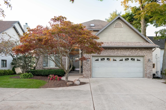 1761 S Shore Dr, Holland, MI 49423 - view of front of home with driveway, a shingled roof, an attached garage, and brick siding