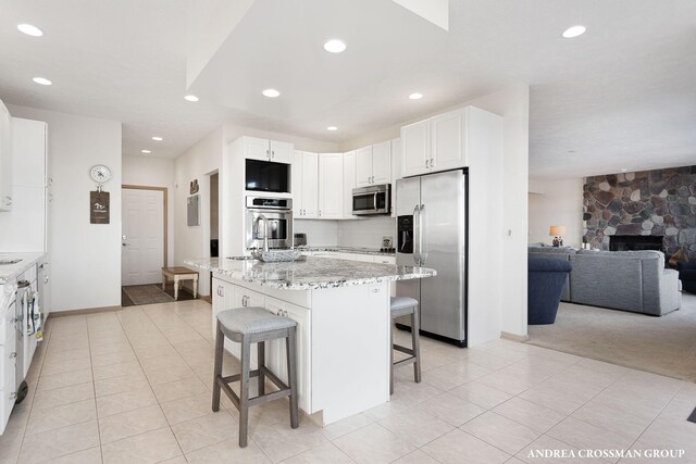 1761 S Shore Dr, Holland, MI 49423 - kitchen featuring a kitchen breakfast bar, open floor plan, recessed lighting, stainless steel appliances, and light stone counters