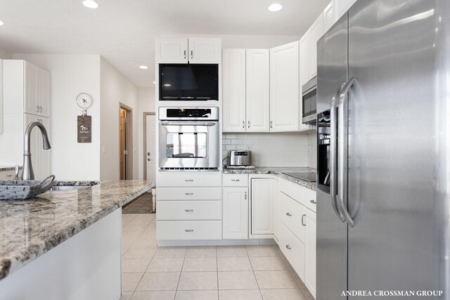 1761 S Shore Dr, Holland, MI 49423 - kitchen with white cabinets, tasteful backsplash, and appliances with stainless steel finishes