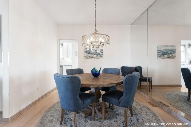1761 S Shore Dr, Holland, MI 49423 - dining room with light wood-style flooring, a notable chandelier, and baseboards