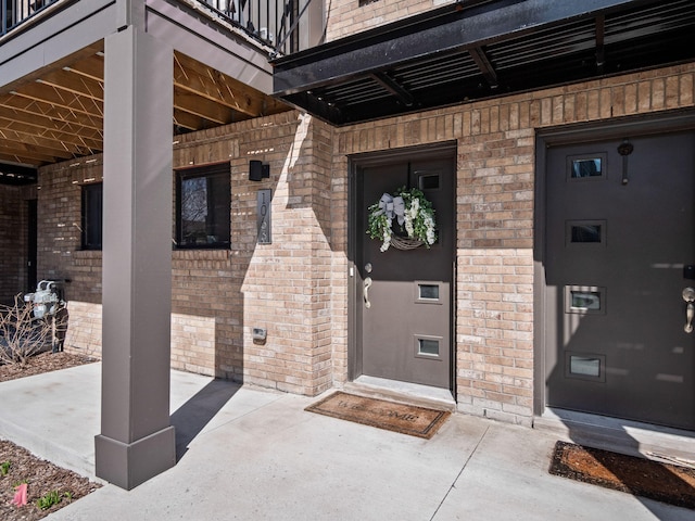 entrance to property with a balcony and brick siding
