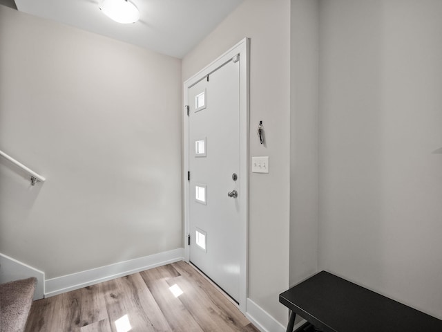 entrance foyer with baseboards, light wood-type flooring, and stairway