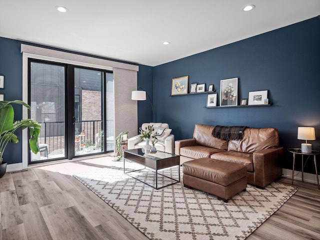 living area with baseboards, wood finished floors, and recessed lighting