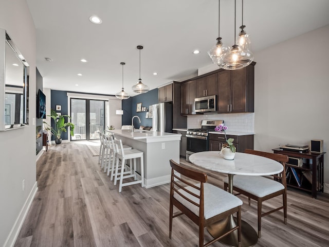 dining area with recessed lighting, baseboards, and light wood-type flooring